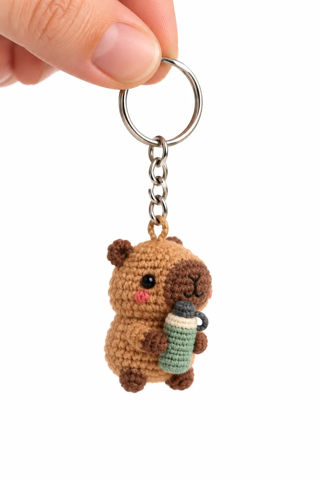 Crochet capybara keychain holding a green takeaway drink cup on a silver keyring