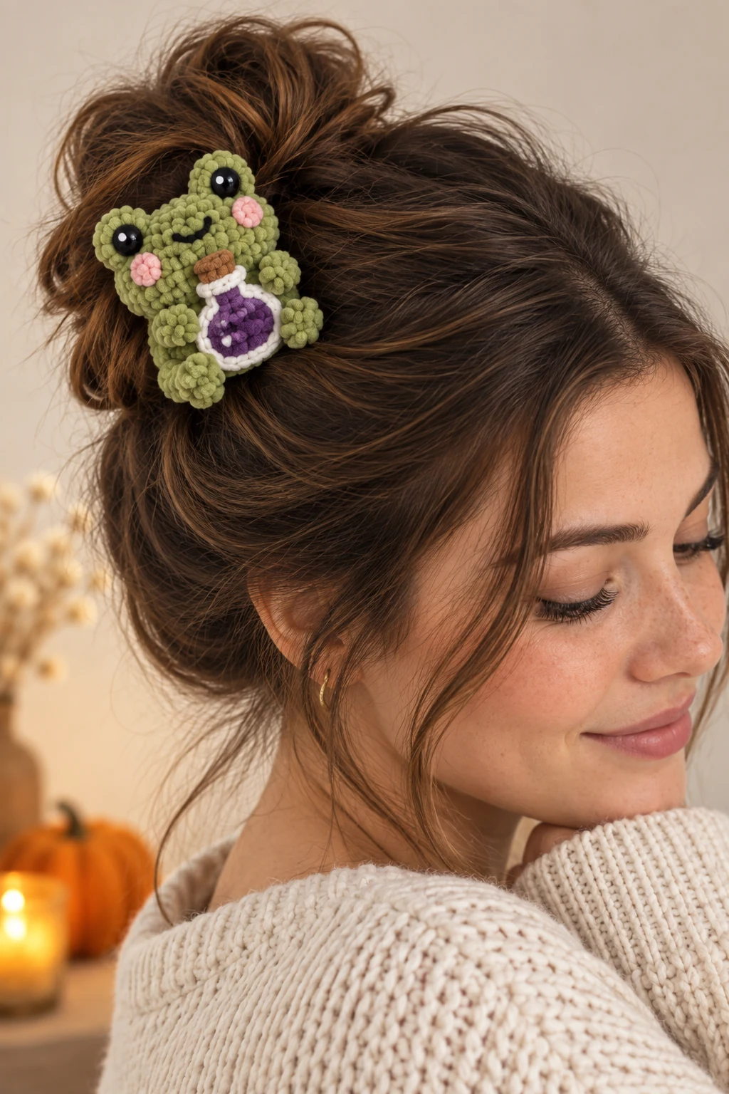 Green crochet frog hair clip holding a purple potion bottle