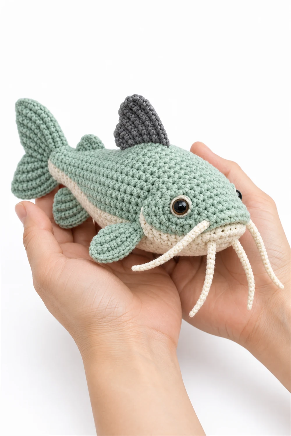 Mint green crochet catfish amigurumi with curly whiskers