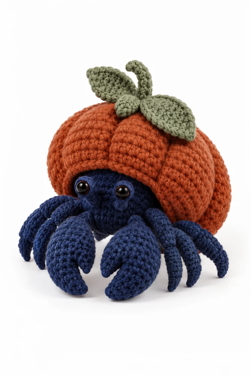 Navy blue crochet hermit crab living in a pumpkin shell